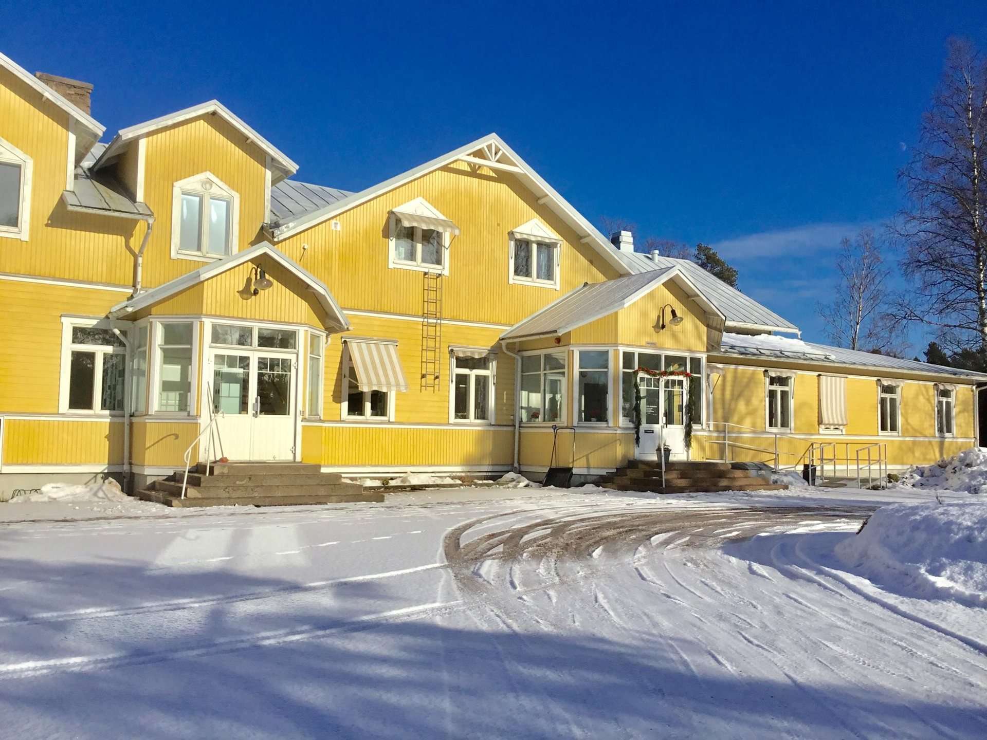 Söderbyn keltainen kunnantalo lumessa ja auringossa