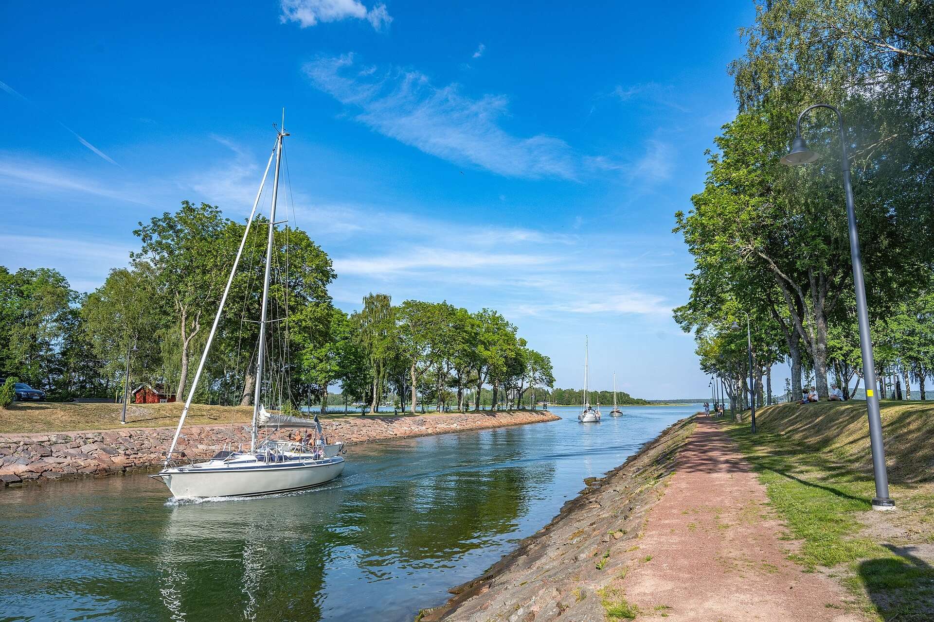 Segelbåt i Lemströms kanal mellan kantade stenstränder