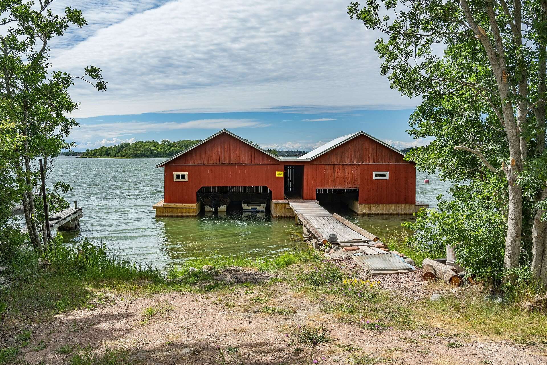 Röda båthus vid en brygga på Nåtö, Lemland