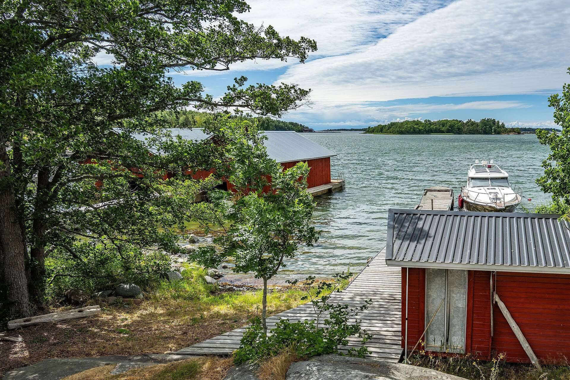 Brygga och rött båthus i skärgården på Nåtö